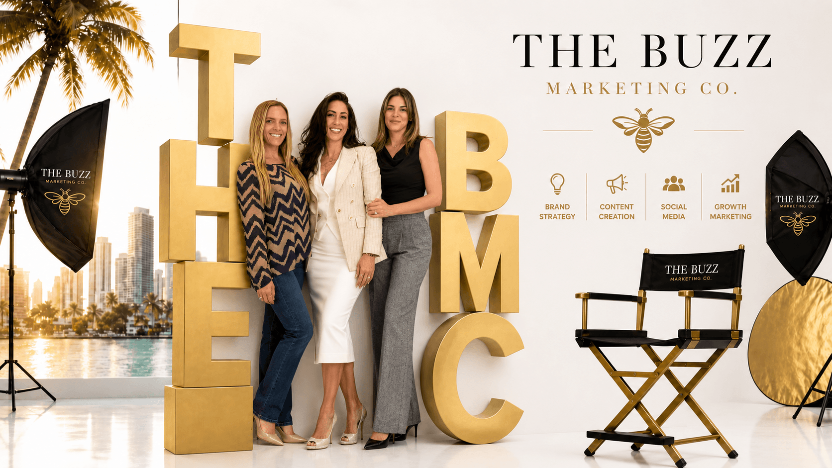 The Buzz Marketing Co founding team in front of the brand wall in San Diego